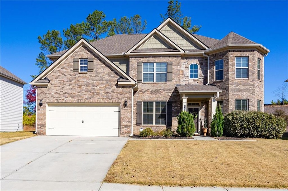 Craftsman inspired home featuring concrete driveway, a garage, brick siding, a front lawn, and a shingled roof