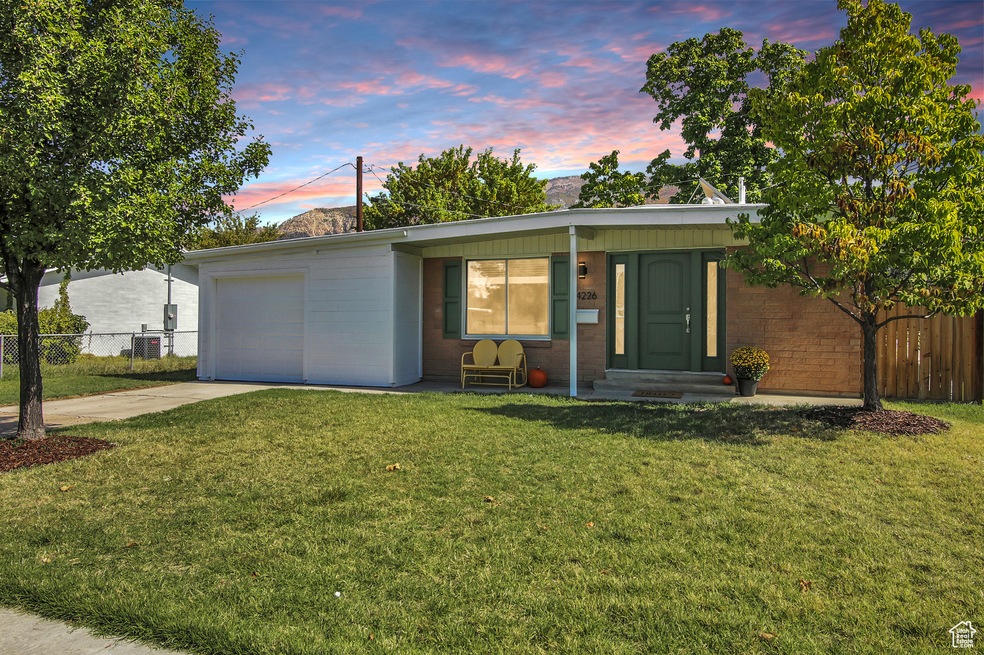 Mid-century inspired home featuring concrete block siding, driveway, a porch, and a garage