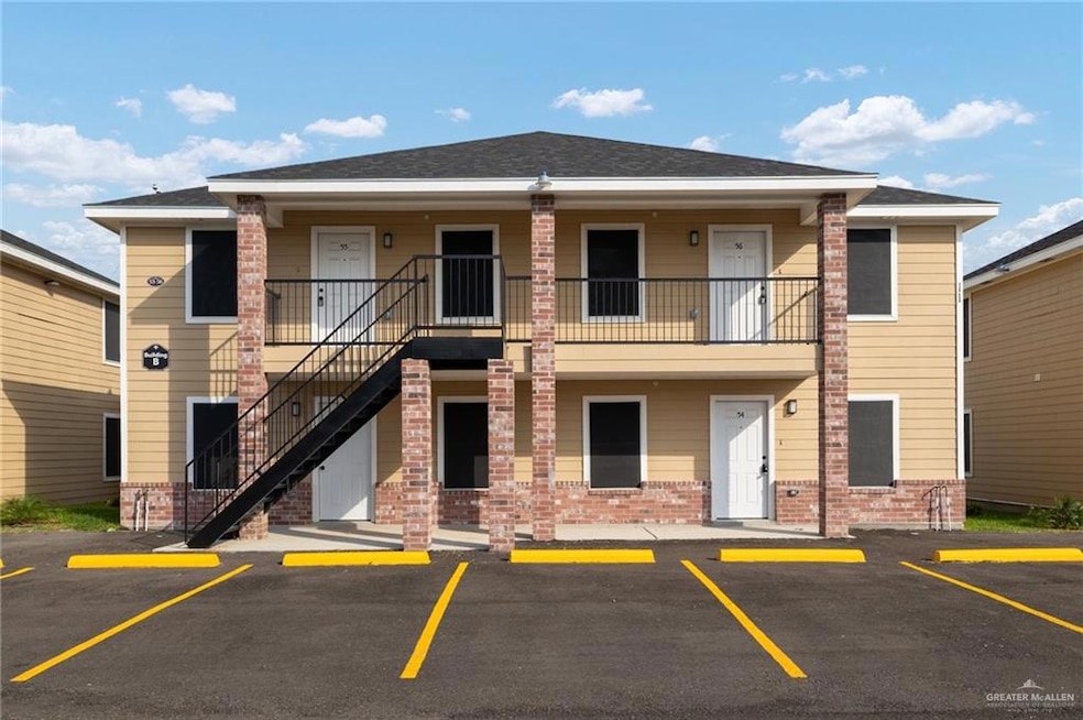 View of property featuring uncovered parking and stairway