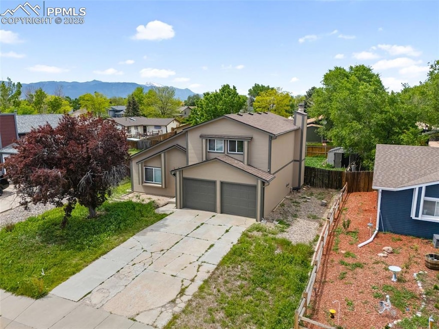 View of front facade with concrete driveway, a garage, and a mountain view