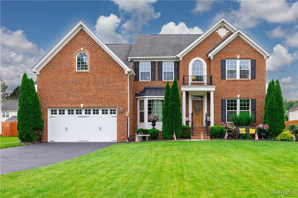 Colonial-style house with brick siding, a front ya
