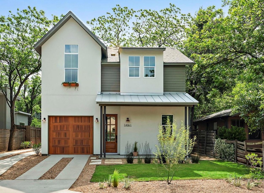 View of front facade with fence, a garage, concre
