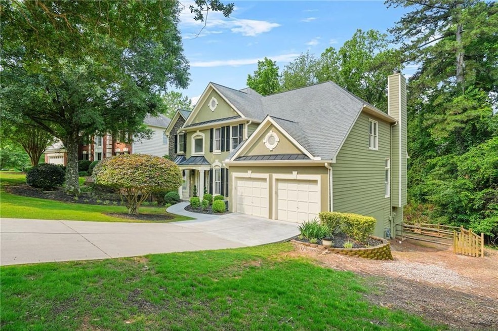 View of front of home featuring driveway, a chimney, an attached garage, a standing seam roof, and a metal roof