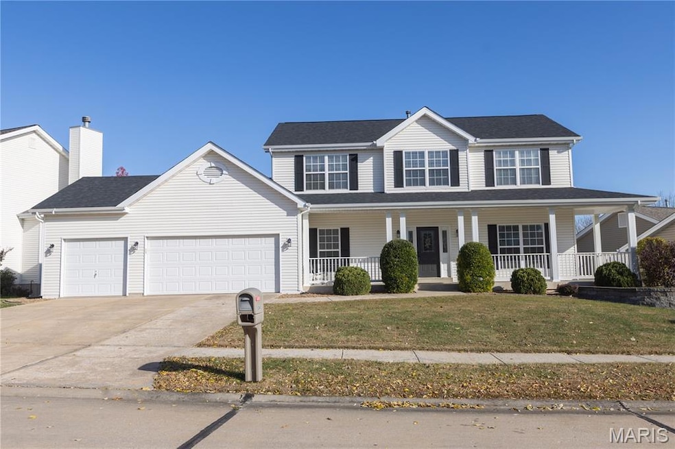 View of front of property with covered porch, driveway, a front yard, an attached garage, and roof with shingles