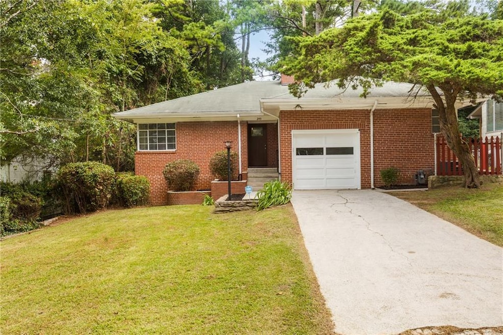 Ranch-style house featuring concrete driveway, a front lawn, brick siding, and a garage