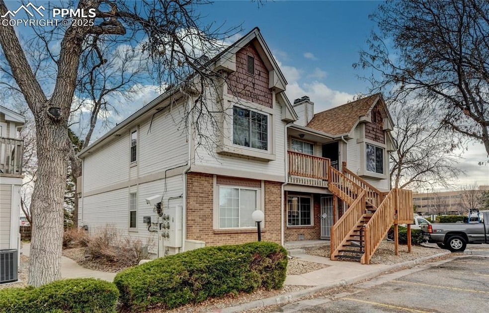 View of front of property with stairway and brick 