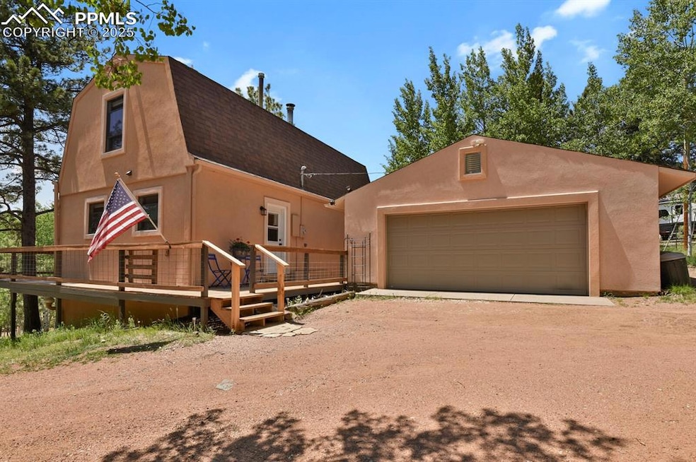 View of front of house with a shingled roof, stucco siding, a deck, and driveway