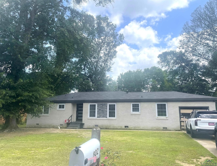 Single story home featuring crawl space, entry steps, brick siding, an attached garage, and a front lawn