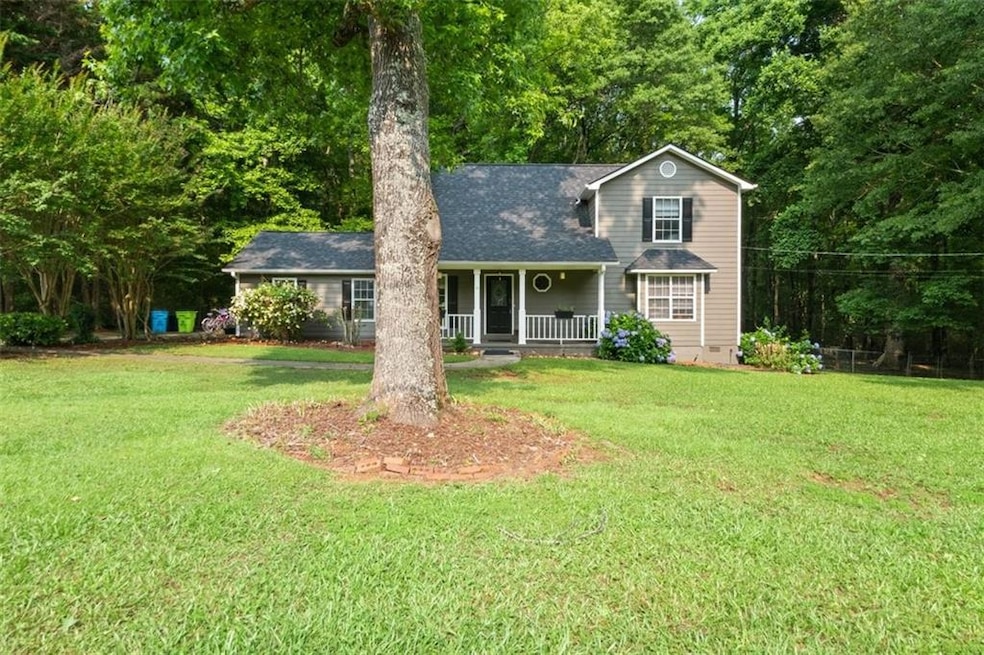 Traditional-style home with covered porch, a front yard, roof with shingles, and crawl space