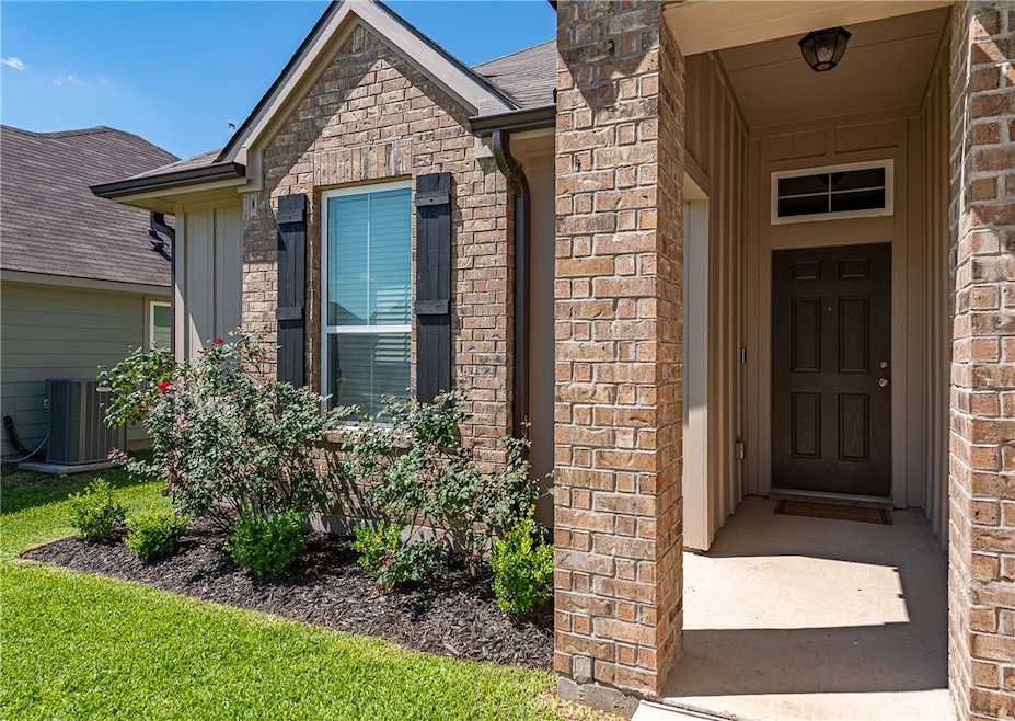 View of exterior entry with brick siding, cooling