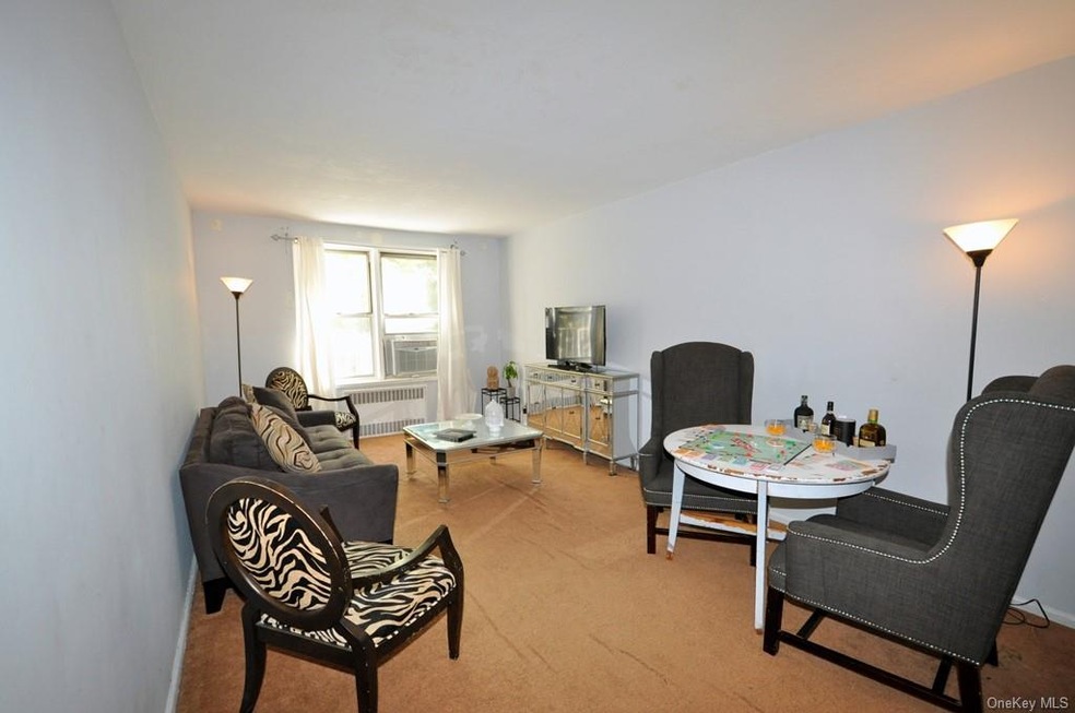 Sunny living room has covered hardwood floors and 