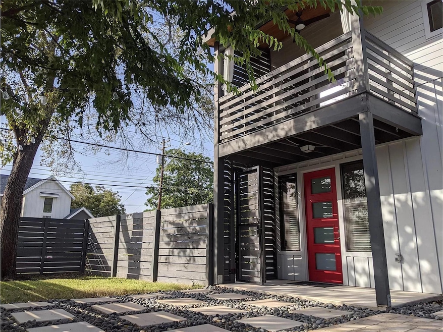 View of exterior entry with a balcony, fence, and