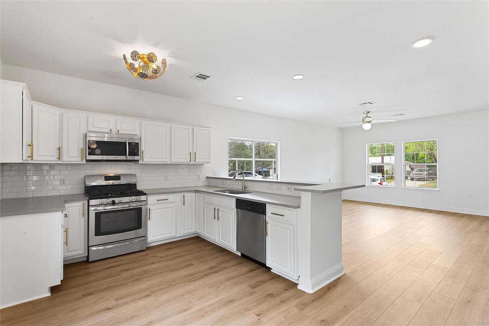 Kitchen featuring a sink, backsplash, a ceiling f
