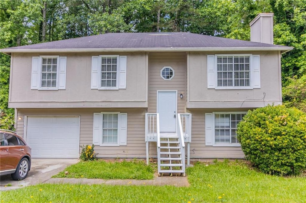 Split foyer home featuring a garage, a chimney, an