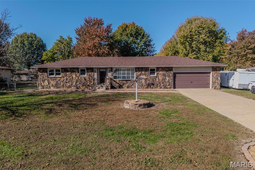 Ranch-style house featuring stone siding, driveway, and a garage