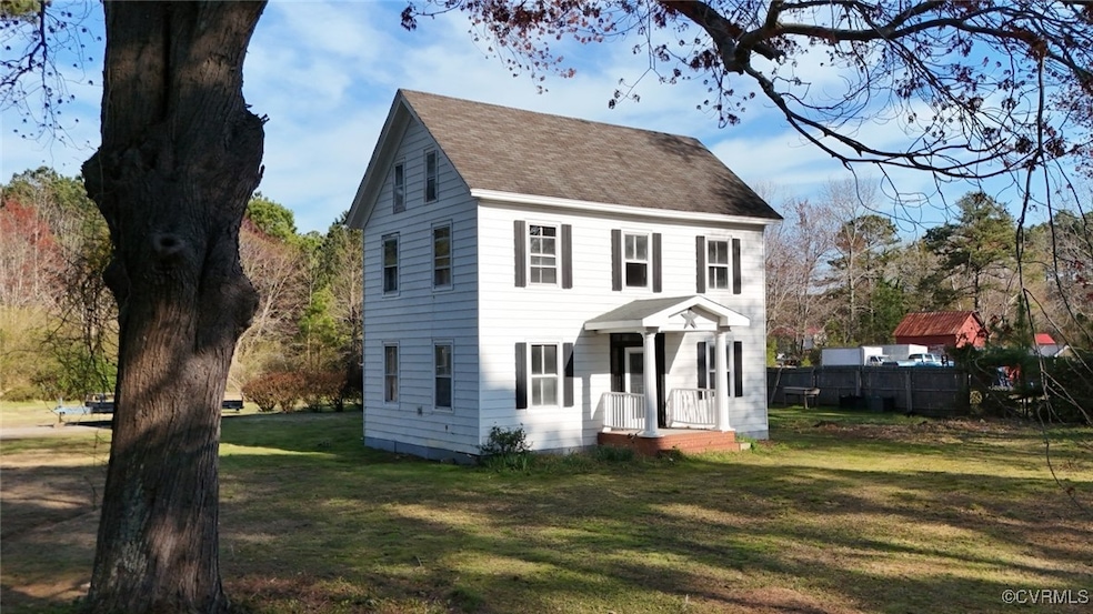 Colonial inspired home with a shingled roof and a front lawn