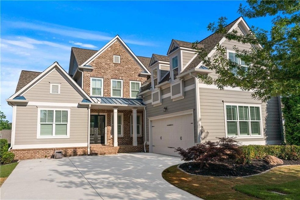View of front of house with driveway, a porch, an attached garage, and brick siding