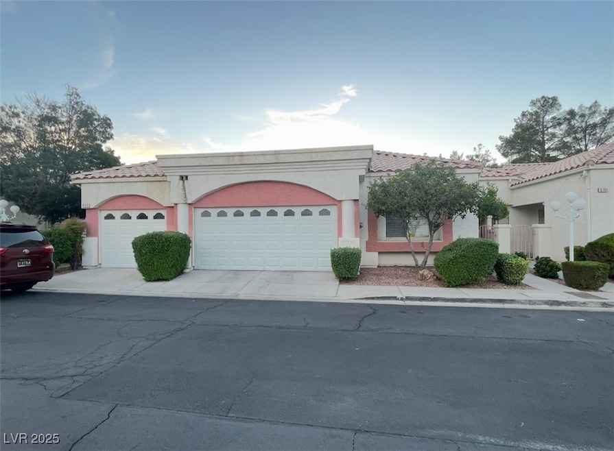 View of front of house with a tile roof, a garage,