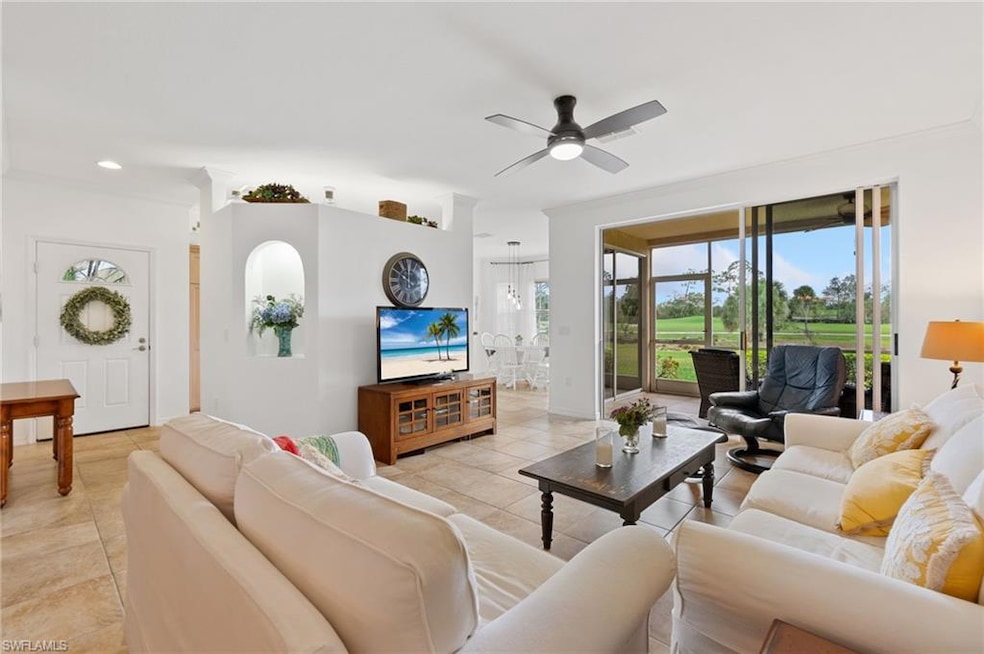 Tiled living room featuring ceiling fan and crown 