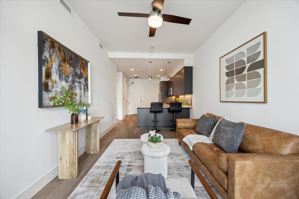 Living area featuring a ceiling fan, dark wood-st