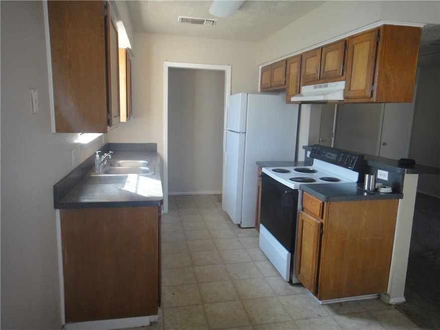 Kitchen with range with electric cooktop, visible 