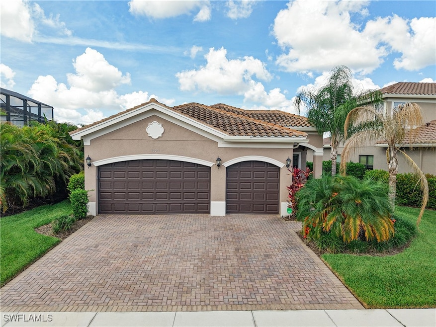 Mediterranean / spanish home with decorative driveway, stucco siding, a garage, and a tile roof