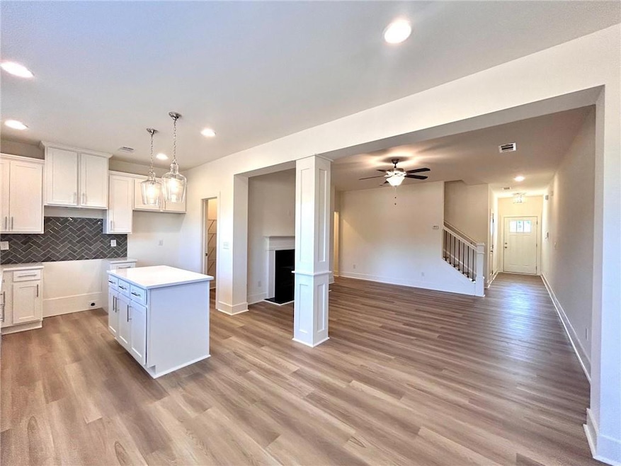 Kitchen featuring white cabinets, light wood-type 