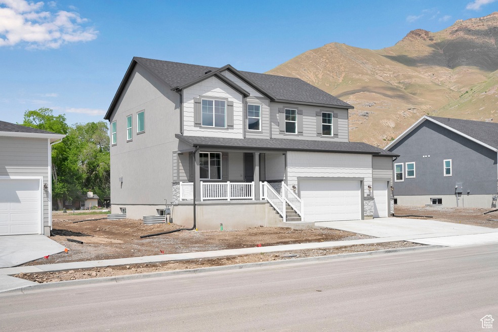 View of front facade with a porch, an attached garage, a mountain view, driveway, and a shingled roof