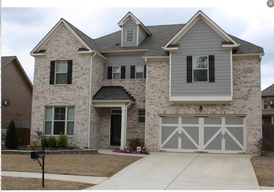 Craftsman house with concrete driveway, an attached garage, brick siding, and roof with shingles