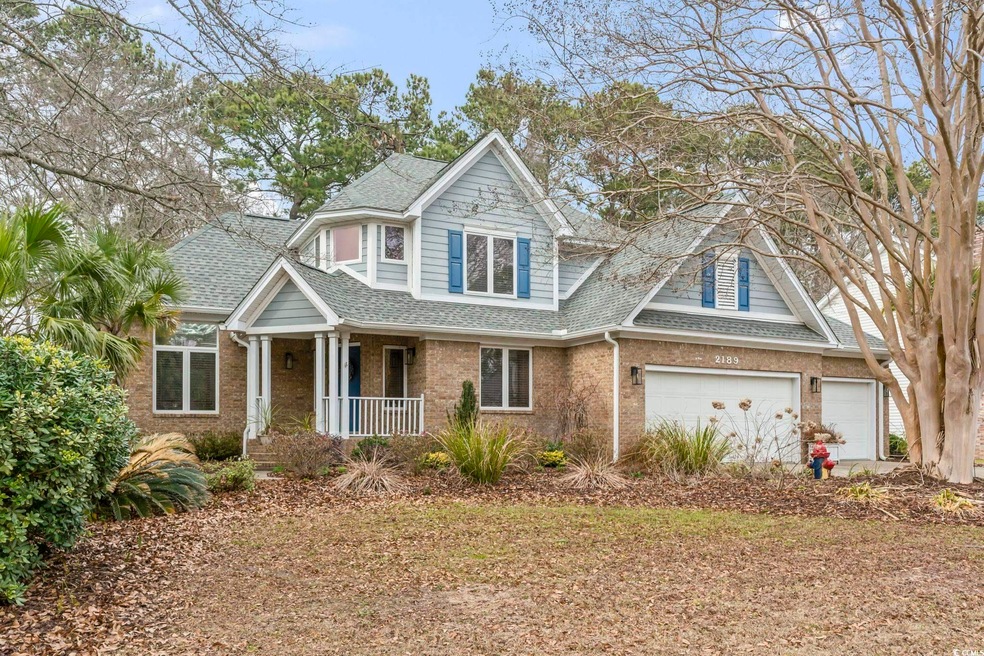 View of front of home with a garage, brick siding,