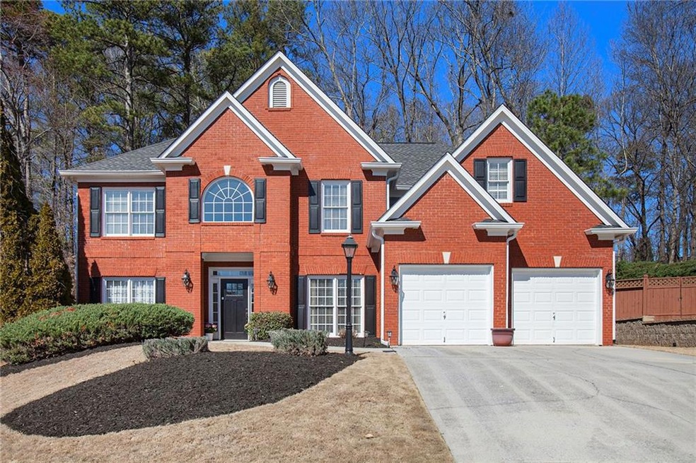 Colonial home featuring driveway, brick siding, an