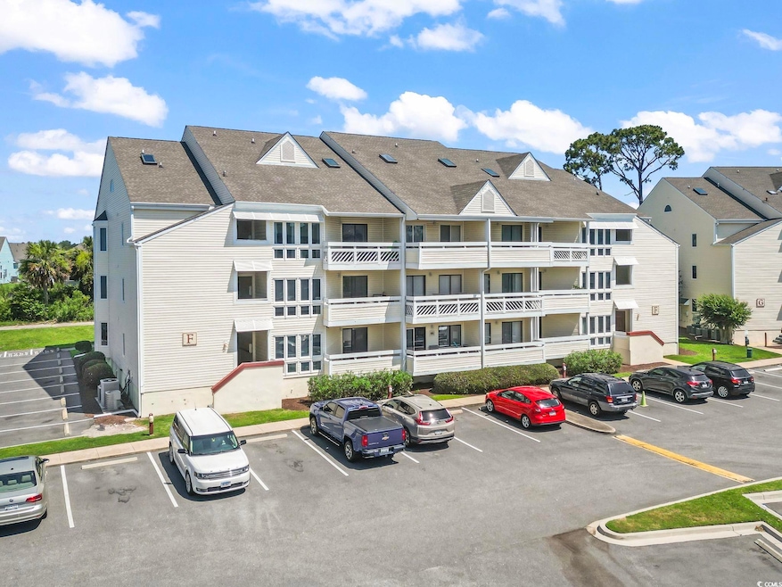 View of building exterior featuring uncovered parking