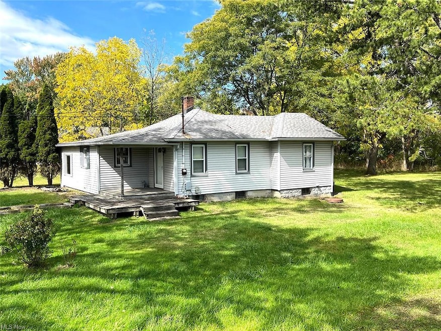Front view of property with small porch and a yard