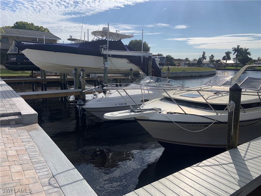 Dock area featuring boat lift and a water view