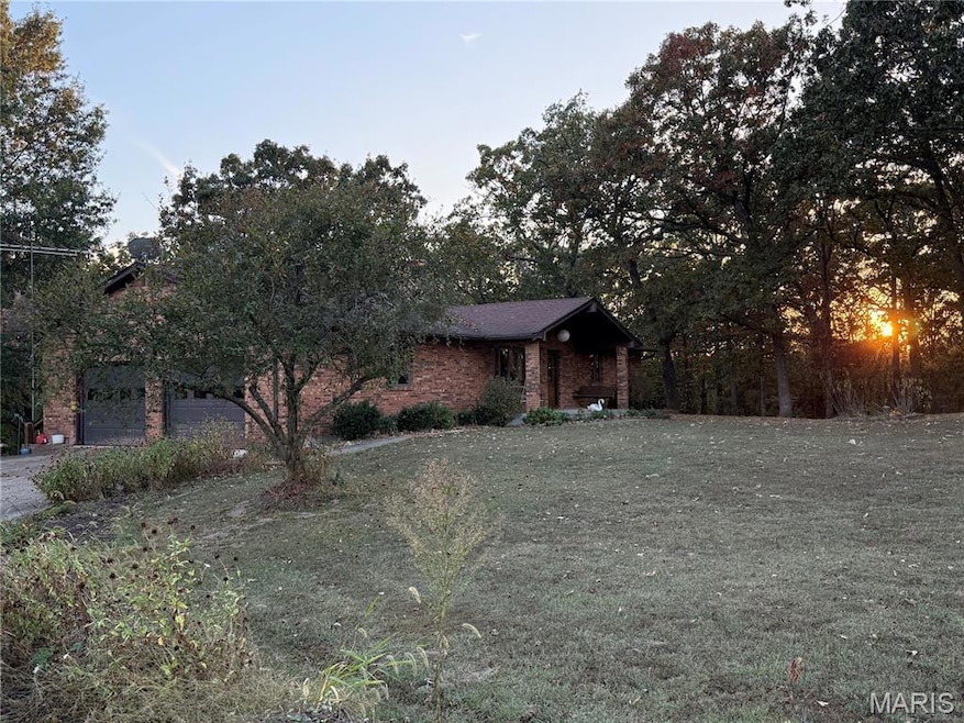 View of front of property with a front lawn, brick siding, and 2 car garage
