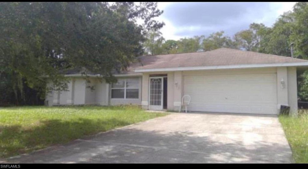 Single story home with a garage, driveway, a front yard, and stucco siding