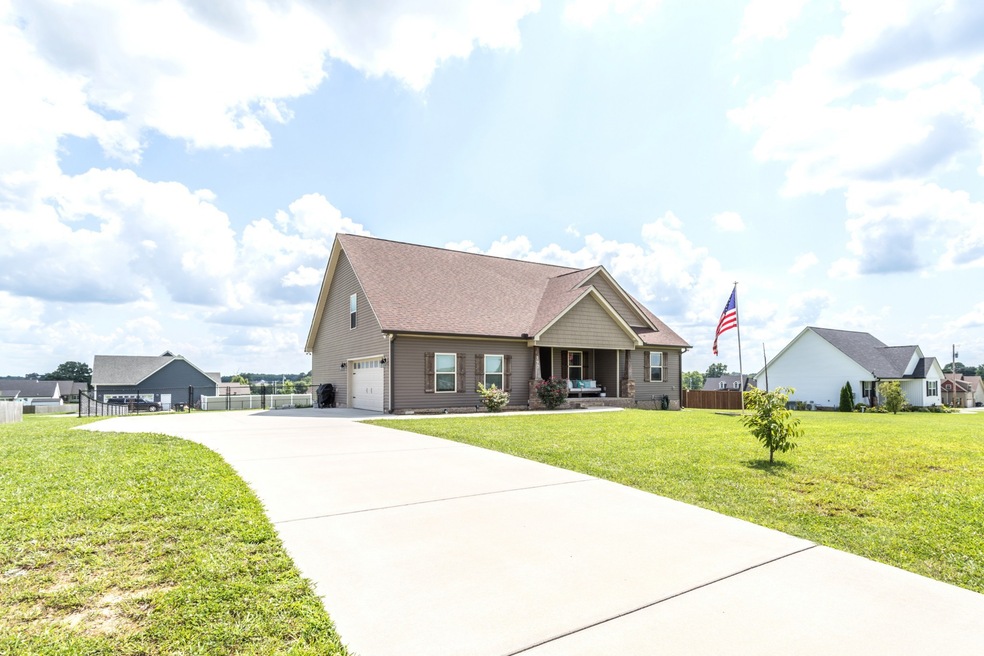 Sitting pretty on a large lot with wide concrete driveway and Old Glory flying high