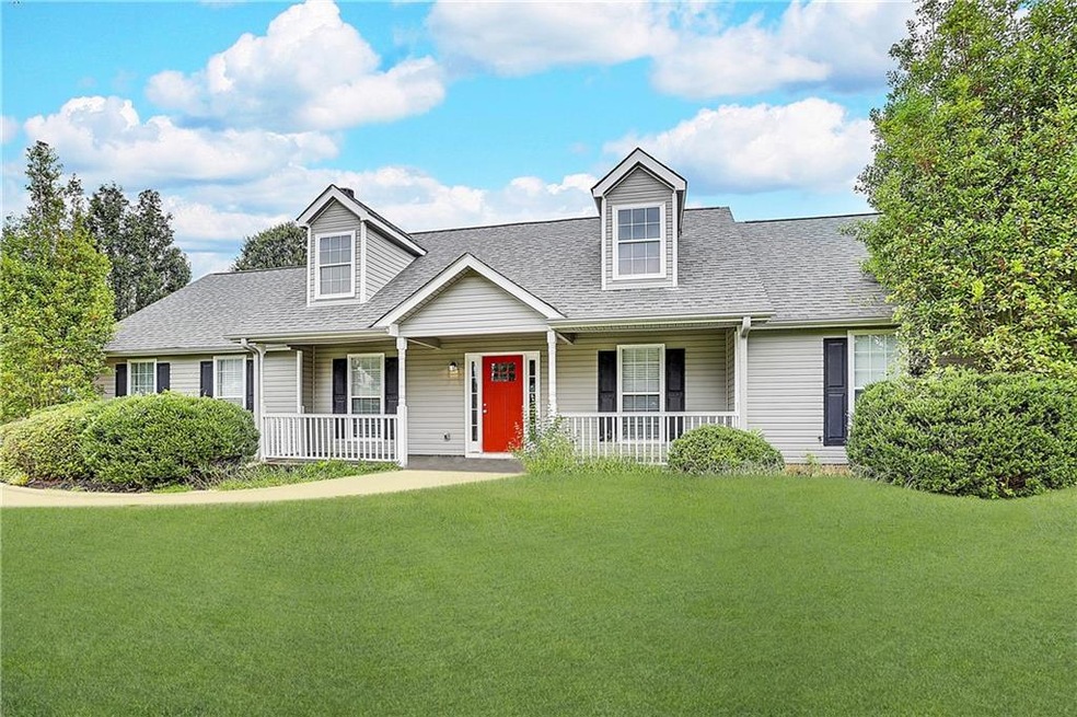 Cape cod home with a front yard and covered porch