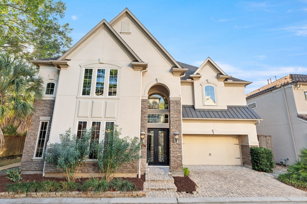 This exquisite home, featuring an ELEVATOR, is situated on a corner lot in an intimate gated community. The stonework elegantly complements the stucco exterior, while the lead glass doors offer a peek inside.