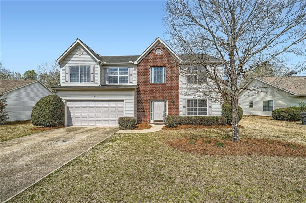 Traditional-style home with a front lawn, an attac