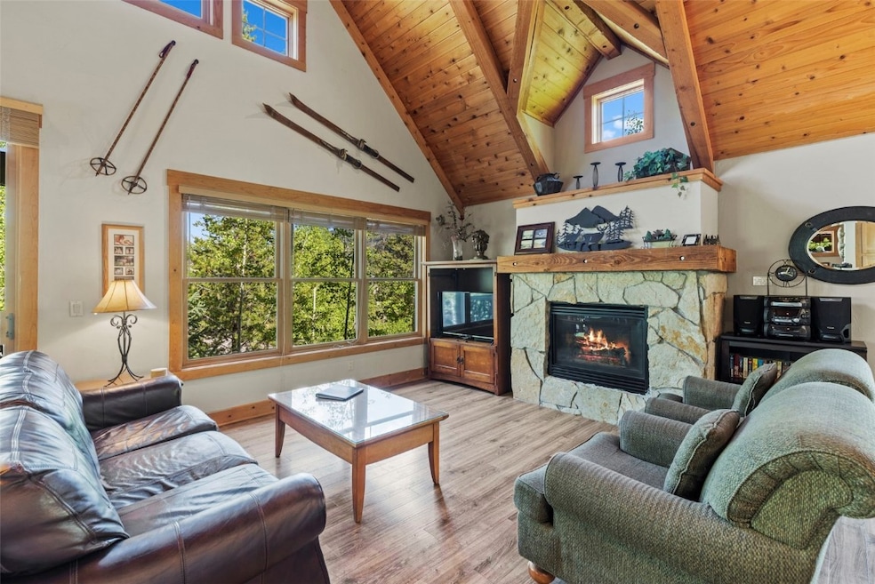 Living area featuring high vaulted ceiling, a fire