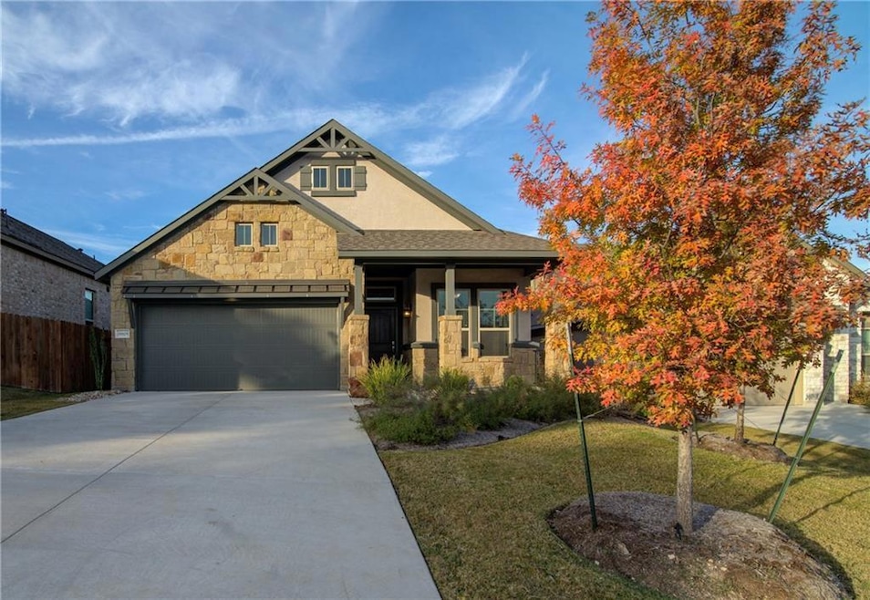View of front of home featuring stone siding, dri
