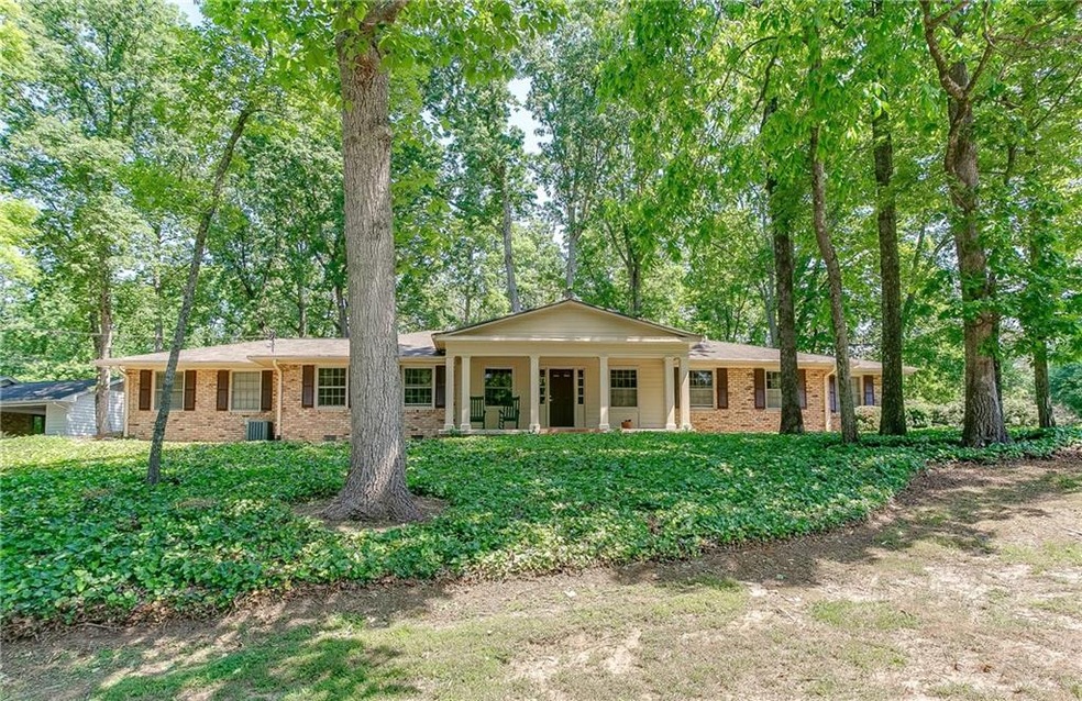 This four-sided brick ranch sits perched on over a