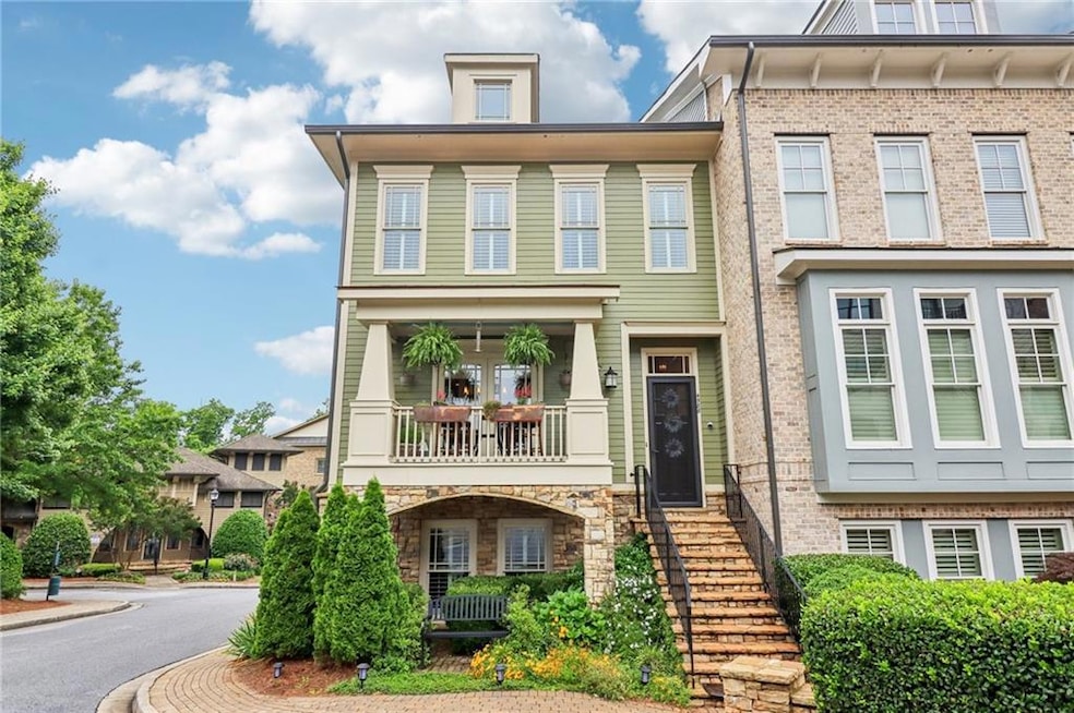 View of front of home with a balcony and stone siding