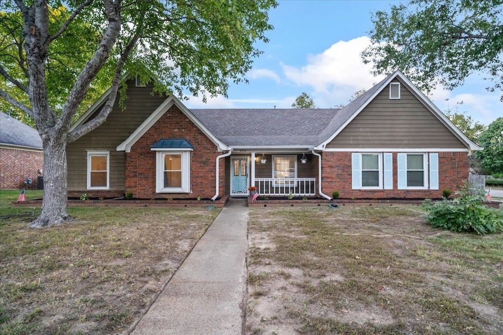 Single story home featuring covered porch, brick siding, a front yard, and roof with shingles
