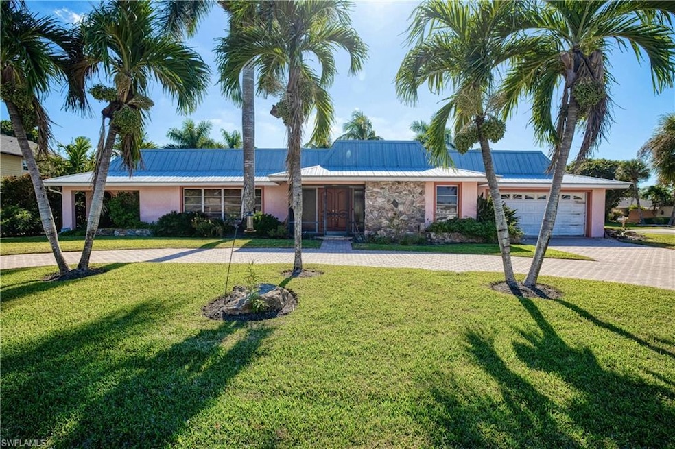 Ranch-style house with stucco siding, decorative driveway, a front yard, and a metal roof