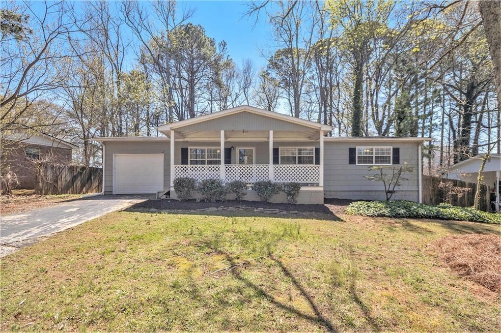 Single story home featuring a garage, a porch, and