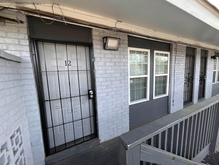 View of exterior entry with brick siding and covered porch