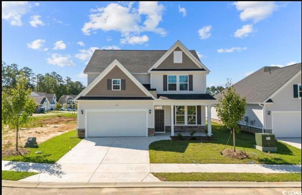 View of front of property featuring driveway, a front lawn, an attached garage, a porch, and stone siding