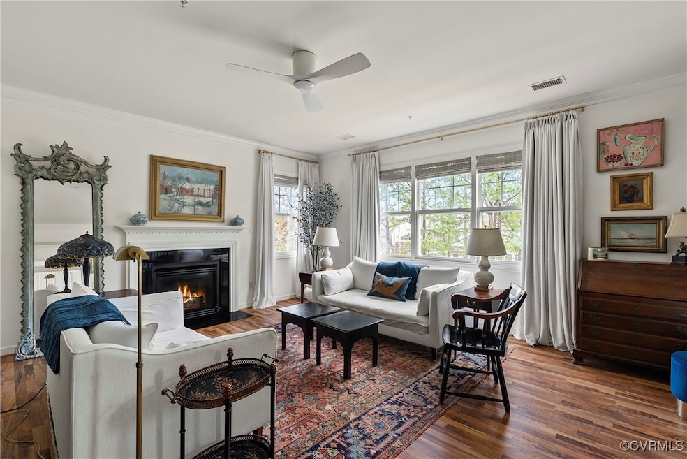 Living area featuring a ceiling fan, crown molding